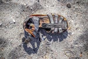 sapato vintage velho em uma praia de areia. foto