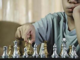menino sério concentrado desenvolvendo gambito de xadrez, estratégia, jogando jogo de tabuleiro para vencedor concentração inteligente e criança pensante enquanto joga xadrez. conceito de aprendizagem, tática e análise. foto