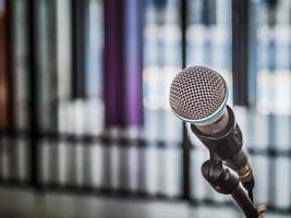 close-up do microfone no fundo desfocado abstrato para discurso na sala de seminários ou comunicação e sala de conferências falando, conceito de fundo. foto