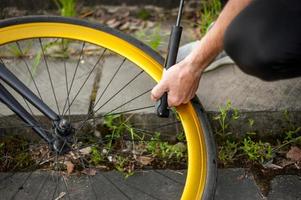 um jovem levanta a roda de sua bicicleta. foto