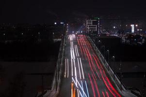 as trilhas de luz do carro na estrada na cidade moderna à noite foto