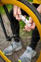 um jovem conserta a roda de sua bicicleta. foto