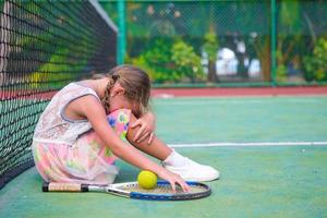 menina triste na quadra de tênis foto