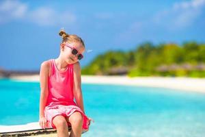 menina adorável na praia durante as férias de verão foto