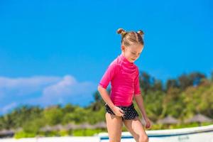 menina adorável na praia durante as férias de verão foto