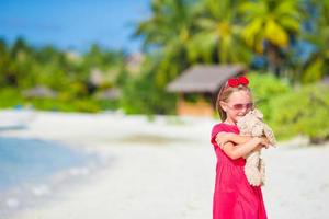 adorável menina brincando com brinquedo durante as férias na praia foto