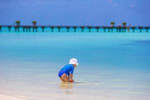 adorável menina brincando com brinquedos de praia durante as férias tropicais foto