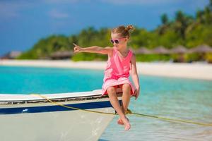 menina adorável barco durante as férias de verão foto
