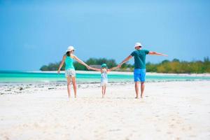 família feliz se divertindo na praia branca foto