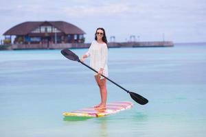 jovem ativa na prancha de stand up paddle foto