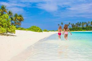 adoráveis meninas se divertindo durante as férias na praia foto