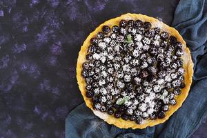 deliciosa torta com amoras em fundo escuro. vista do topo foto