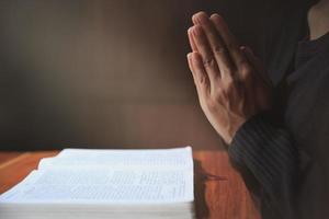 rezando as mãos com fé na religião e crença em deus em fundo escuro. respeitar. gesto de mãos namaste ou namaskar. foto