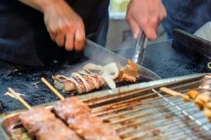 cozinhar à mão usando fatias de lula de corte de faca foto