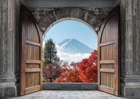 abra a grande porta de madeira com o monte fuji-san e a árvore de bordo do outono no céu azul foto