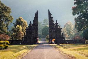 antigo portão de bali com caminho no jardim foto