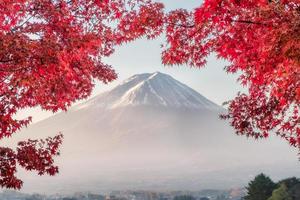 monte fuji com cobertura de folhas de bordo vermelho de manhã no lago kawaguchiko foto