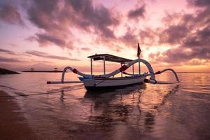 antigo barco de pesca tradicional janggolan na beira-mar ao nascer do sol colorido foto