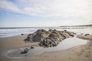 pilha de pedras em uma praia de areia no oceano foto