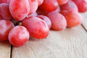 uvas vermelhas em fundo de madeira foto