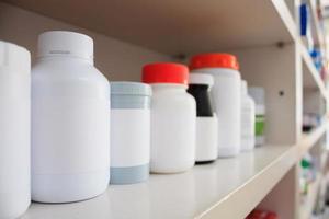 frascos de remédios dispostos na prateleira da farmácia