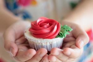 mão segure o cupcake dos namorados foto