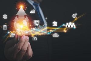 crescimento de negócios de seta. empresário segurando lâmpada estão planejando estratégias e lucros de análise de um negócio. gráfico gráfico de crescimento econômico. uma estratégia de negócios, financeiro, marketing e bancário. foto