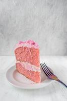 fatia fina festiva de bolo de aniversário rosa com flores de glacê e vista lateral do garfo