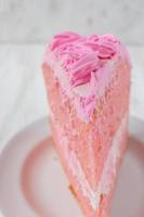 fatia fina festiva de bolo de aniversário rosa com close-up de flores de glacê foto