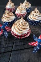 cupcakes vermelhos brancos e azuis com topos de redemoinho de merengue torrado foto