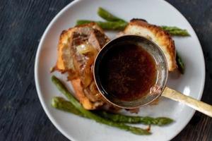 concha de molho com caldo de carne sobre pudim de yorkshire com carne e aspargos foto