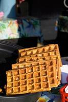 close-up de waffle tradicional rústico no festival de comida de rua. gastronomia de serviço de cozinha ao ar livre e conceito de comida para viagem foto