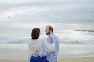 um casal apaixonado, homem e mulher aproveitando as férias de verão em uma praia paradisíaca tropical com água do mar claro e cênica foto