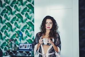 menina encaracolada com caneca de café foto