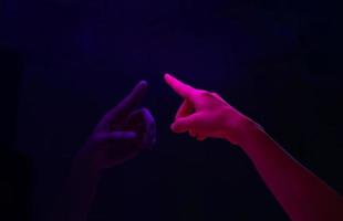 mulher apontando o dedo para a tela em branco no monitor azul no meio da noite. foto
