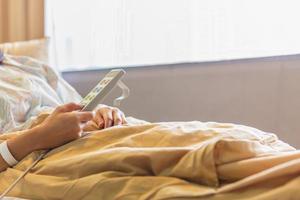 mão de paciente mulher usando controle remoto para ajustar cama de nível no hospital. foto