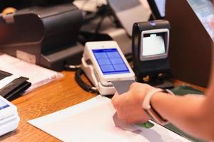 mulher pagando a conta no café inserindo o cartão de crédito no leitor de cartão de crédito. foto