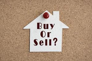 comprar ou vender pergunta no modelo de casa de papel. conceito de investimento imobiliário foto
