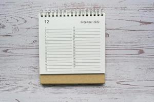 planejador de dezembro e calendário organizador 2022 na mesa de madeira. diretamente acima. foto