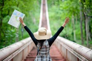 jovens turistas e um mapa com um sorriso ficam felizes em viajar para vários locais. foto