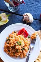 risoto com frango e legumes em um prato com talheres foto