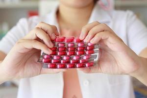 close-up de mãos médicas segurando pílulas foto