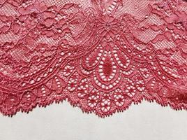 renda tecido rosa elegante. elemento de acabamento de roupas íntimas em um fundo branco. foto