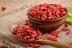 bagas vermelhas secas de goji em colher de pau foto