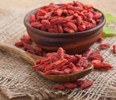 bagas vermelhas secas de goji em colher de pau foto