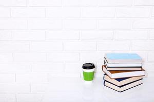 literatura educacional. xícara de café e livros na mesa em uma aula. vista superior e copie o espaço. foco seletivo