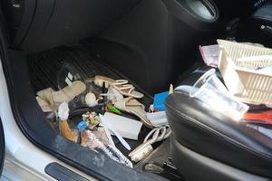 interior sujo do carro, tapete na área dos pés tem lixo, resíduos de alimentos, sujeira derramada sobre ele. precisa ser limpo e aspirado por dentro. conceito de manutenção do carro foto