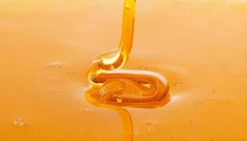 macro de gotejamento de mel fresco espesso foto