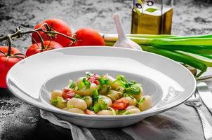 nhoque vegetariano com cebolinha e tomate foto