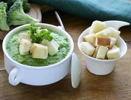 sopa de creme de brócolis vegetal com croutons brancos e salsa foto